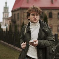 young-man-holding-phone-outdoors